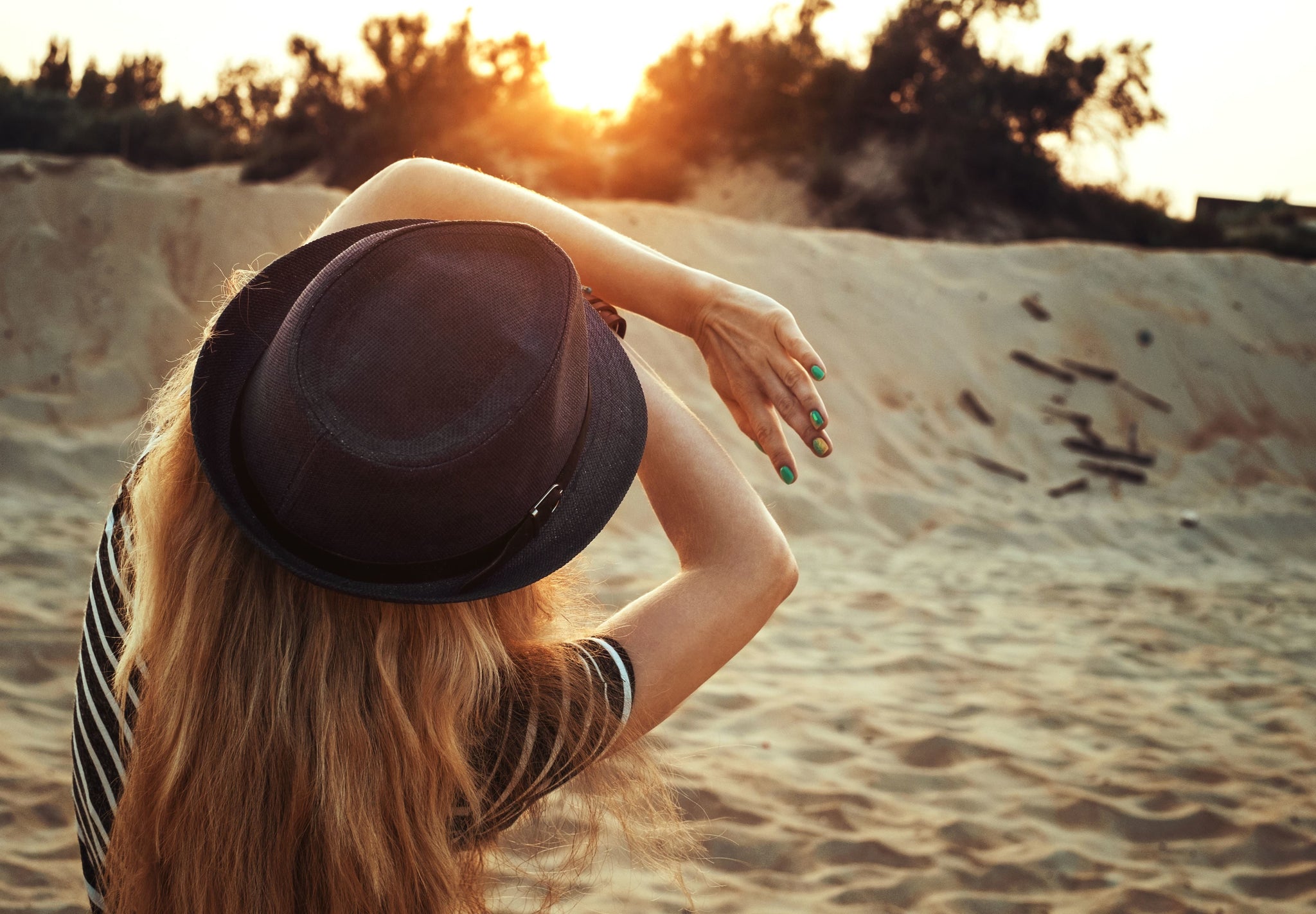 woman shielding herself from the sun on the beach