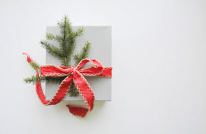 wrapped present with a sprig of evergreen branch