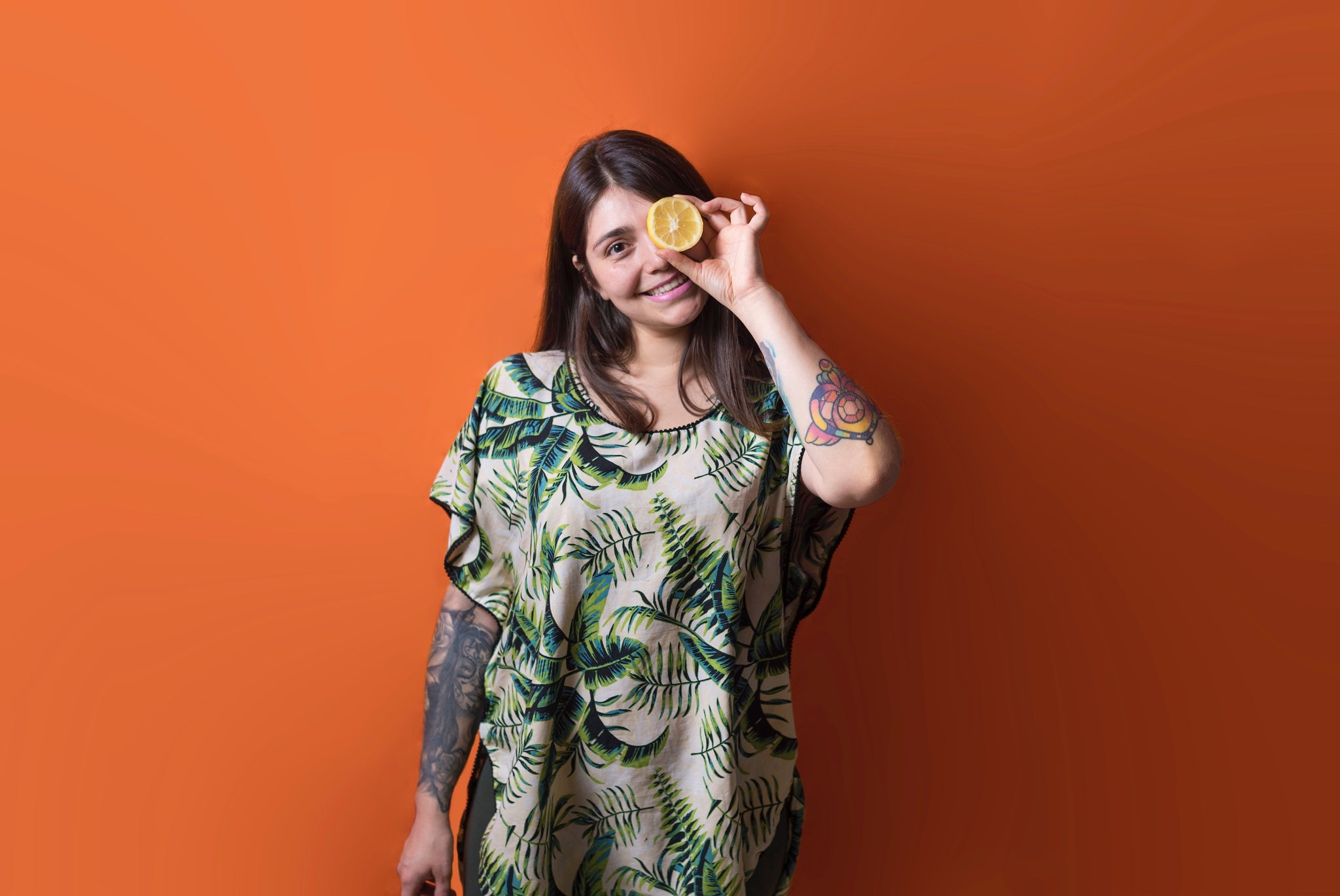 woman holding citrus over one eye